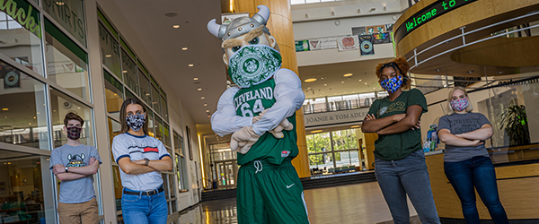 Magnus standing with Cleveland State University students wearing masks