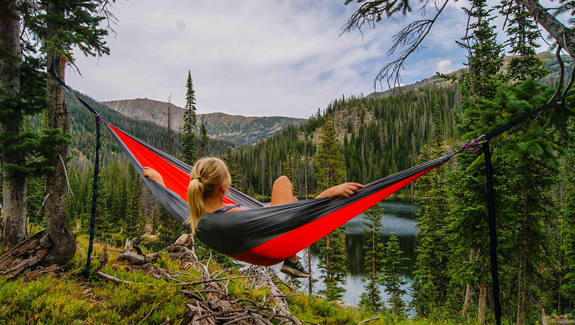 woman relaxing in hammock by lake