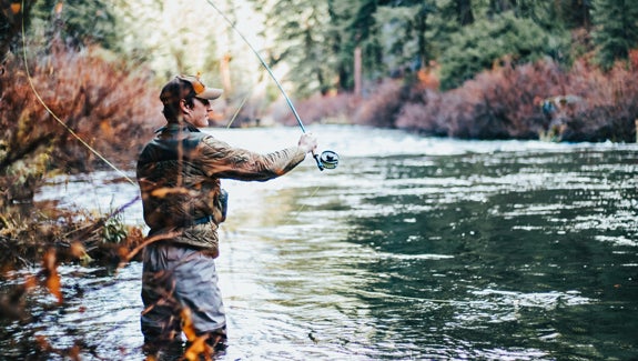 man fly fishing in river