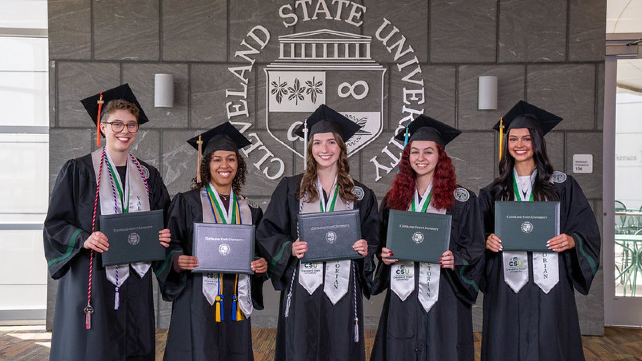 Valedictorians posing in front of CSU seal wearing commencement regalia. Grace Moon, Leilah Flores, Sarah McCartney, Vivian France and Sydney Wisnor are pictured left to right. 