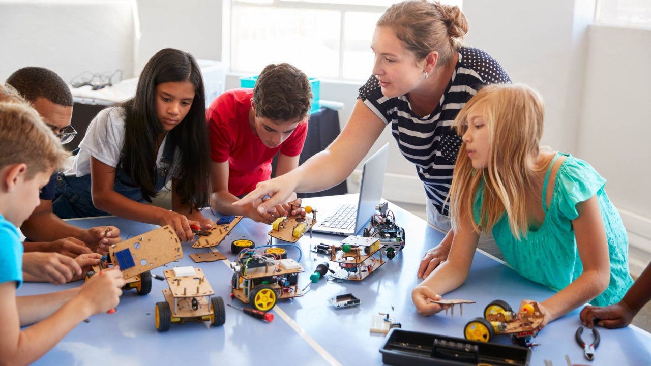 Teacher and elementary students in a classroom working on a project
