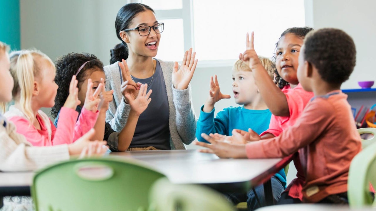 Teacher and young children talking around a table
