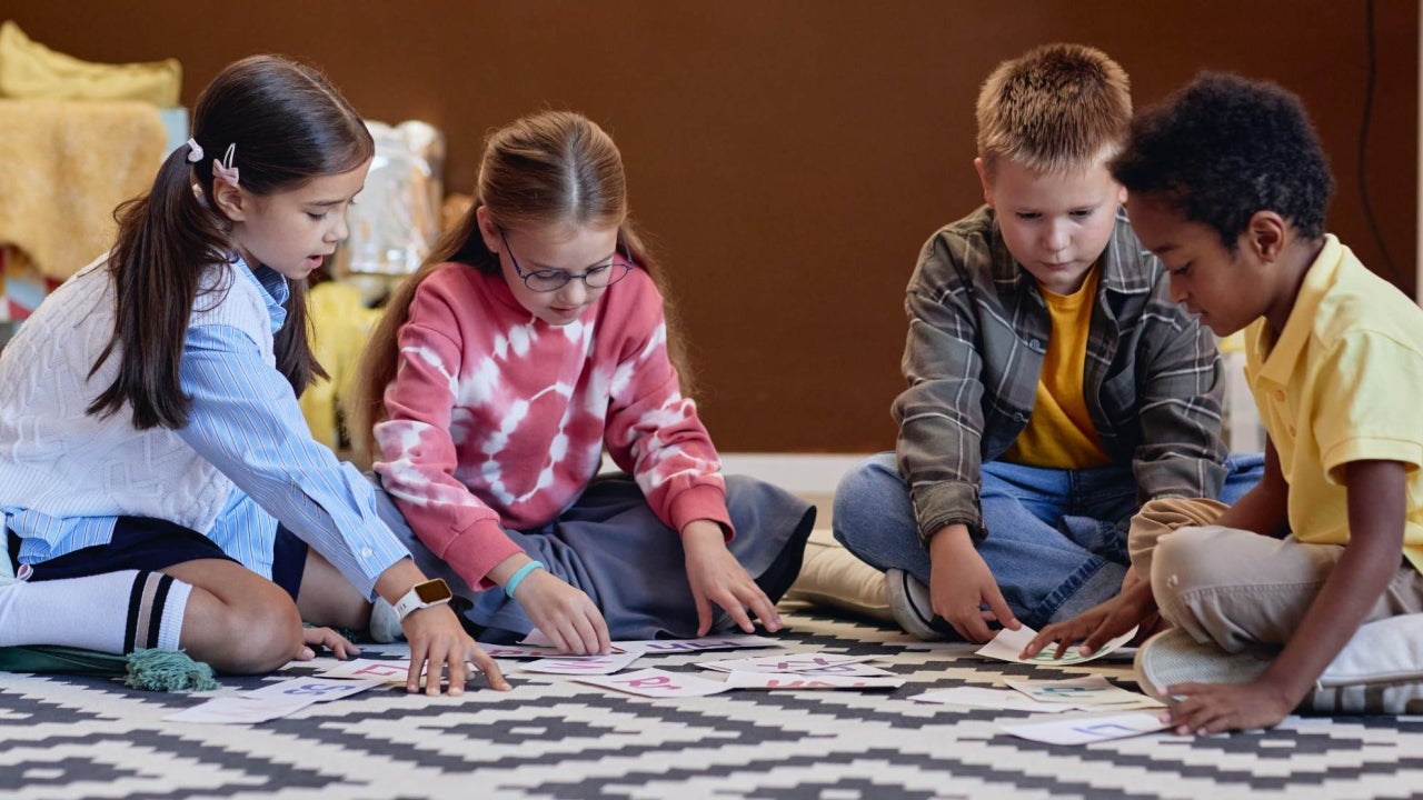 Children sitting on a classroom floor working on an activity together