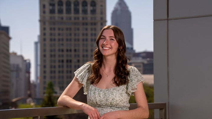 Sarah McCartney posing in front of Cleveland skyline