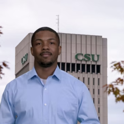 Adam, a CSU virtual engagement officer, posing in front of Rhodes Tower. 