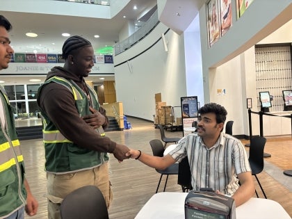 Viking safety ambassador shaking the hand of a student outside of Chick-Fil-A