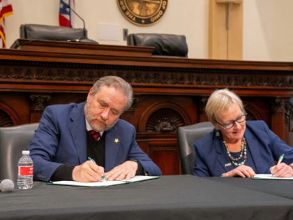 Attorney General Dave Yost and President Laura Bloomberg, signing an agreement