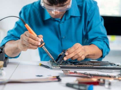 Student working in an electronics circuit board in a lab