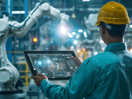 Workers in hard hats in a manufacturing environment using AI