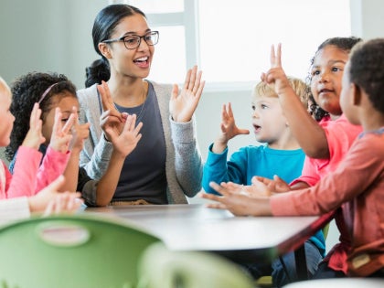 Teacher and young children talking around a table